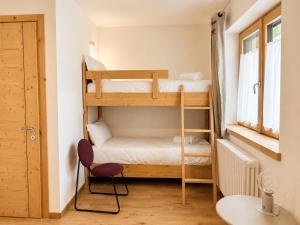 a small room with two bunk beds and a table at Blu Betulle, Free Park and Ski room in Camporosso in Valcanale