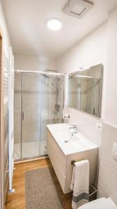 a white bathroom with a sink and a shower at Blu Betulle, Free Park and Ski room in Camporosso in Valcanale +9 photos