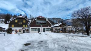 a house with snow on the ground in front of it at Blu Betulle, Free Park and Ski room in Camporosso in Valcanale