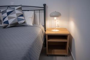 a bed with a night stand next to a bed with a lamp at Studios Kerasioti in Pefki