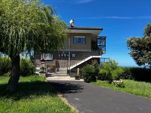 a large house with stairs and a tree at La Atalaya del Cabo - 4800 in Arnuero