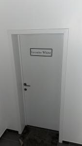 a white door with a sign that reads la suite window at La Suite White wellness Jacuzzi & Sauna in Seraing