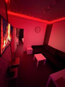 a red room with a couch and a tv at La Suite White wellness Jacuzzi & Sauna in Seraing
