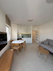 a kitchen and living room with a table and a couch at Stan 11 in Đenovići