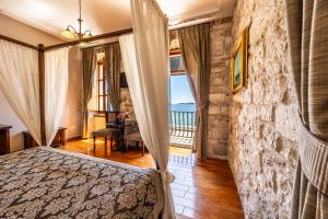 a bedroom with a bed with a stone wall at Heritage Boutique Hotel Adriatic-Adults only in Orebić