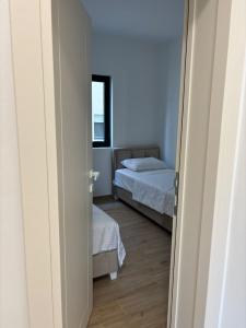 a bedroom with two beds and a window at Stan 11 in Đenovići