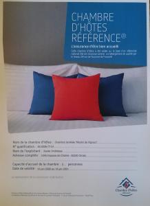 a sign that sayschange phones reference on a bed with two pillows at La chambre d'hôtes du moulin de Vignars in Ginals