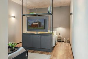 a living room with a tv and a bed at ipartment Leverkusen @HOME by Best Western in Leverkusen