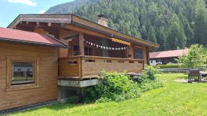 a wooden cabin in a field with a mountain at Chalet am Lechweg in Elbigenalp