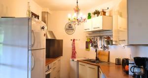 a kitchen with white cabinets and a refrigerator at Minavita - Vue mer, Plage à pied, Ruppione, Corse in Pietrosella