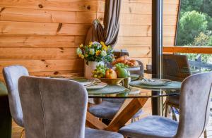 a dining room with a table with fruit and flowers at Forest Cuib in Predeluţ +22 photos