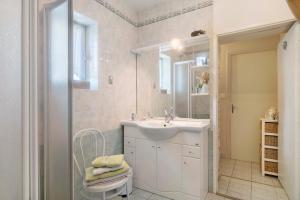 a white bathroom with a sink and a shower at Chambres D'hôtes Le Peux in Saint-Pierre-le-Vieux