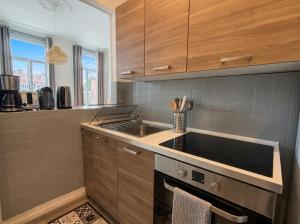 a kitchen with a sink and a stove at Beau 2 pièces climatisé, beaux volumes et lumineux - toutes commodités - Lille Gares direct en 30 minutes in Tourcoing +3 photos