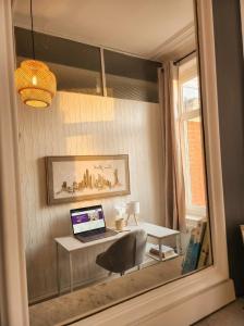 a desk with a laptop computer on it in a room at Beau 2 pièces climatisé, beaux volumes et lumineux - toutes commodités - Lille Gares direct en 30 minutes in Tourcoing
