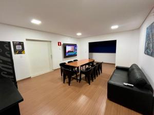 a living room with a table and chairs and a couch at Hotel Valadares in Alfenas +9 photos