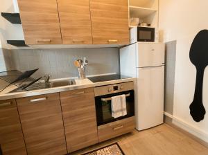 a small kitchen with a sink and a refrigerator at Beau 2 pièces climatisé, beaux volumes et lumineux - toutes commodités - Lille Gares direct en 30 minutes in Tourcoing