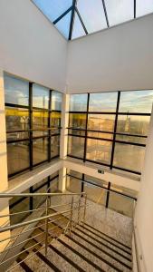 a room with a staircase in a building with windows at Hotel Valadares in Alfenas