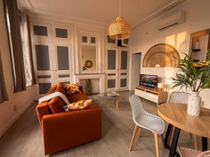 a living room with a couch and a table at Beau 2 pièces climatisé, beaux volumes et lumineux - toutes commodités - Lille Gares direct en 30 minutes in Tourcoing