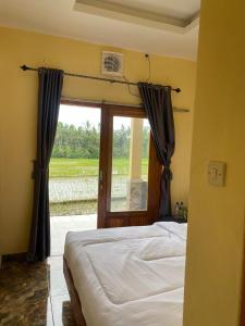 a bedroom with a bed and a large window at Sabin view homestay in Banyuwangi