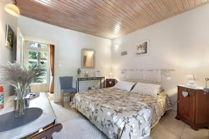 a bedroom with a bed and a desk and a window at Chambres D'hôtes Le Peux in Saint-Pierre-le-Vieux