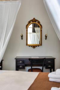 a bedroom with a mirror and a desk with a bed at La Dama Stanca in Narni