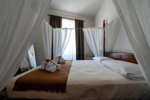 a bedroom with a large bed with white curtains at La Dama Stanca in Narni +17 photos