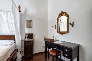 a bedroom with a desk with a bed and a mirror at La Dama Stanca in Narni