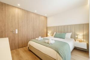 a bedroom with a large bed with two towels at Seaside Beach Condo by Minho's Guest in Apúlia