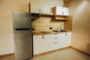 a kitchen with a stainless steel refrigerator and white cabinets at Casa Monti in Ijevan +2 photos
