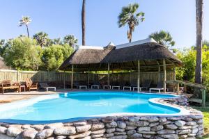a swimming pool with a gazebo at Palmwag Campsite in Palm