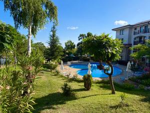 a swimming pool in a yard with trees and a building at Delfin Port Apartments - Prime Location & Parking & Pet Friendly in Sveti Vlas +98 photos