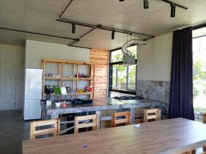 a kitchen with a wooden table and a refrigerator at IO House in Urekis Sadguri