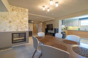 a dining room with a table and a fireplace at Green Galini Villa Pelion in Káto Lekhónia