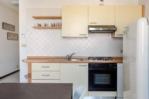 a kitchen with a sink and a stove top oven at Harbour View Apartment - Elite Grado Centro in Grado
