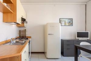 a white refrigerator in a kitchen with a sink at Harbour View Apartment - Elite Grado Centro in Grado