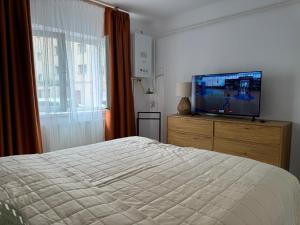 a bedroom with a bed and a flat screen tv at Cazare Târgu Secuiesc in Târgu Secuiesc