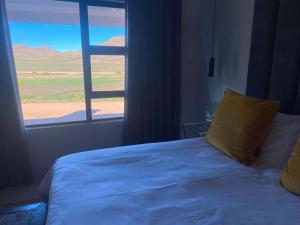a bedroom with a bed and a window with a view at Springbok Guest Farm in Springbok +19 photos