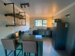 a kitchen with a refrigerator and a table and chairs at Springbok Guest Farm in Springbok