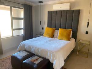 a bedroom with a large bed with yellow pillows at Springbok Guest Farm in Springbok