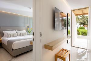 a bedroom with a bed and a window at Agapi Beach Resort Premium All Inclusive in Amoudara Herakliou