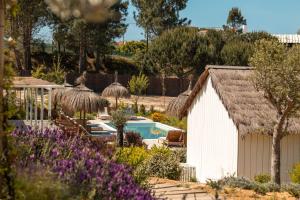 a garden with a white shed and a swimming pool at Quinta Amala in Melides