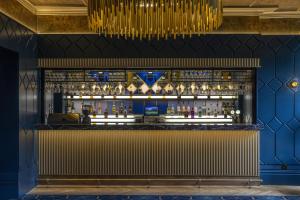 a bar in a restaurant with a blue wall at Best Western Abbots Barton Hotel in Canterbury