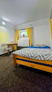 a bedroom with a bed and a desk and a window at Ubytko 151 Broumov in Broumov