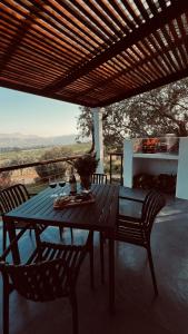 a wooden table with two chairs and a table with wine glasses at Die Kothuis in Wolseley