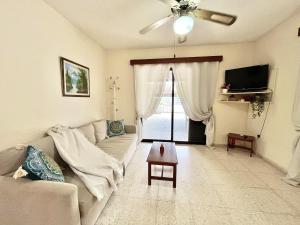 a living room with a couch and a ceiling fan at STAY Sea Gem Townhouse in Meneou
