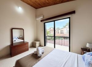 a bedroom with a bed and a mirror and a balcony at STAY Sea Gem Townhouse in Meneou