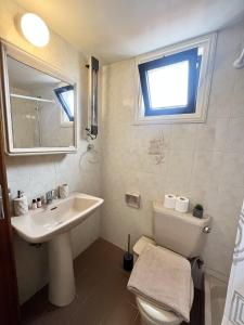 a bathroom with a sink and a toilet and a window at STAY Sea Gem Townhouse in Meneou +26 photos