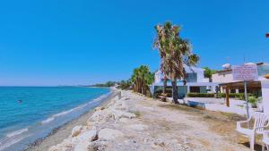 a beach next to a house and the ocean at STAY Sea Gem Townhouse in Meneou