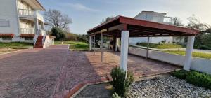 a building with a pavilion next to a street at Olive Tree Villa in Preveza