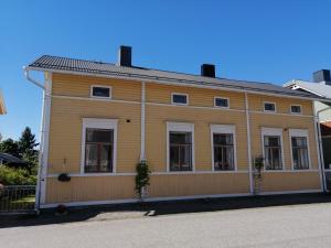 a large wooden house with windows on a street at Foggy Island B&B in Kaskö +6 photos